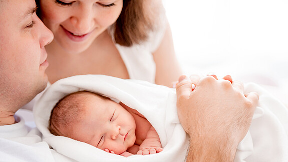 Familienstartzeit Junge Familie mit ihrem Neugeborenen.
