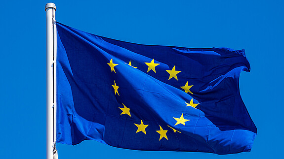 Aktuelles aus dem Herzen der EU - Juni Das Foto zeigt eine Europaflagge, die im Wind flattert.