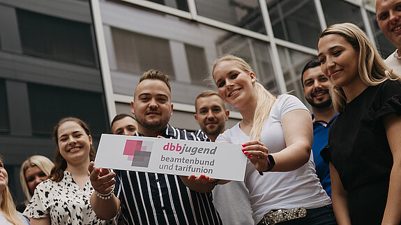 START-Broschüre - dbb jugend Zu sehen sind Mitglieder der dbb jugend mit einem Schild, auf dem "dbb jugend" steht.