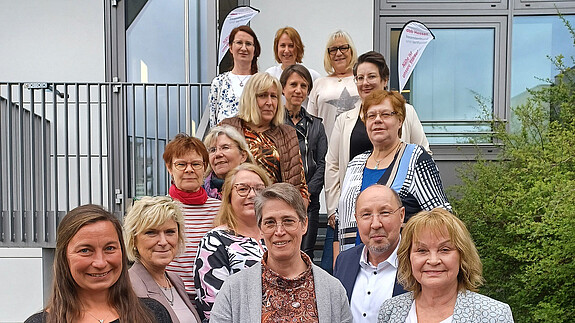 Landeshauptversammlung der dbb frauen Hessen in Frankfurt Eine Gruppe Menschen steht auf einer Treppe vor einem Haus und schaut in die Kamera.