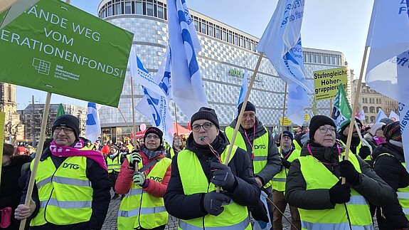 Menschen in gleben Warnwesten demonstrieren auf einem öffentlichen Platz