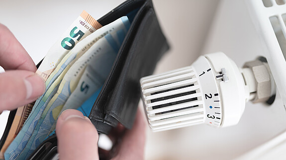 Energieentlastungsgesetz Ein Heizkörper und ein offenes Portemonnaie