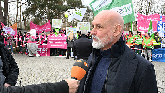 Demo in Potsdam am 14.3.25 - Fotostrecke Das Foto zeigt Impressionen von der Demonstration in Potsdam vor Beginn der dritten Verhandlungsrunde am 14.3.2025: Zu sehen sind Demonstrierende mit Fahnen und Plakaten sowie Vertreter der Gewerkschaften, die Reden halten.