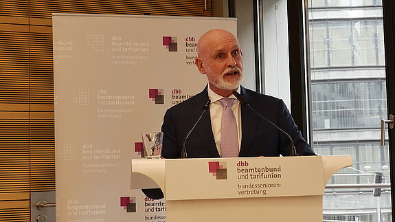 Volker Geyer: „Wir werden uns dem entgegenstellen“ Zu sehen ist Volker Geyer, dbb Bundesvorsitzender der am Podium steht und zur dbb bundesseniorenvertretung spricht.